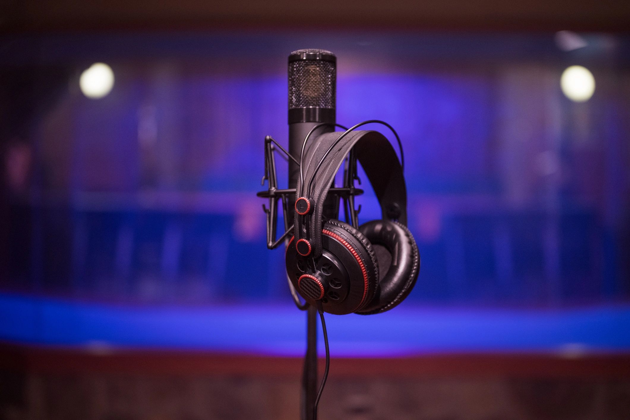 Professional microphone and headphones in a dark recording studio