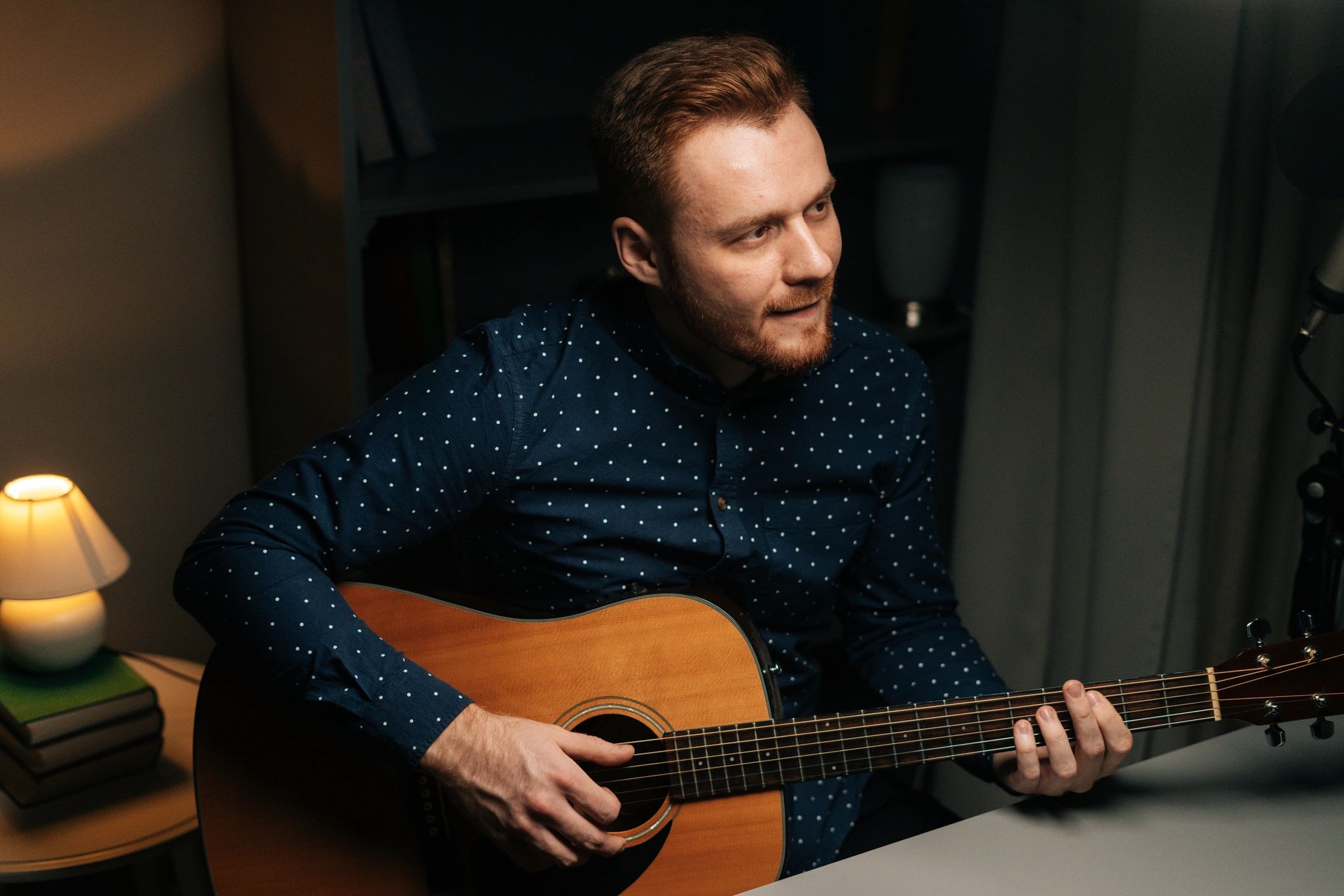 Singer recording music with microphone in a dark studio