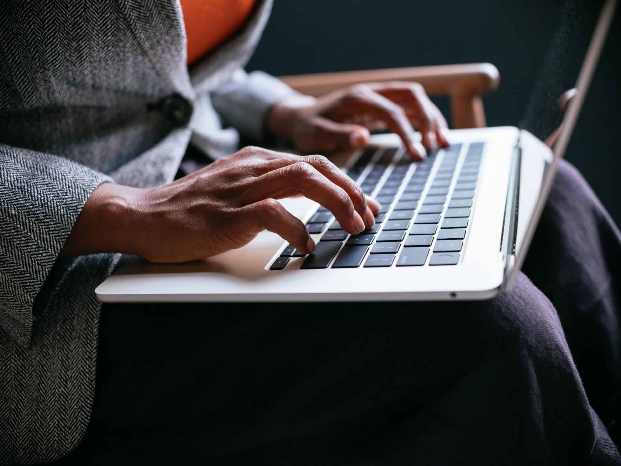 Hands typing on a laptop for online customer support