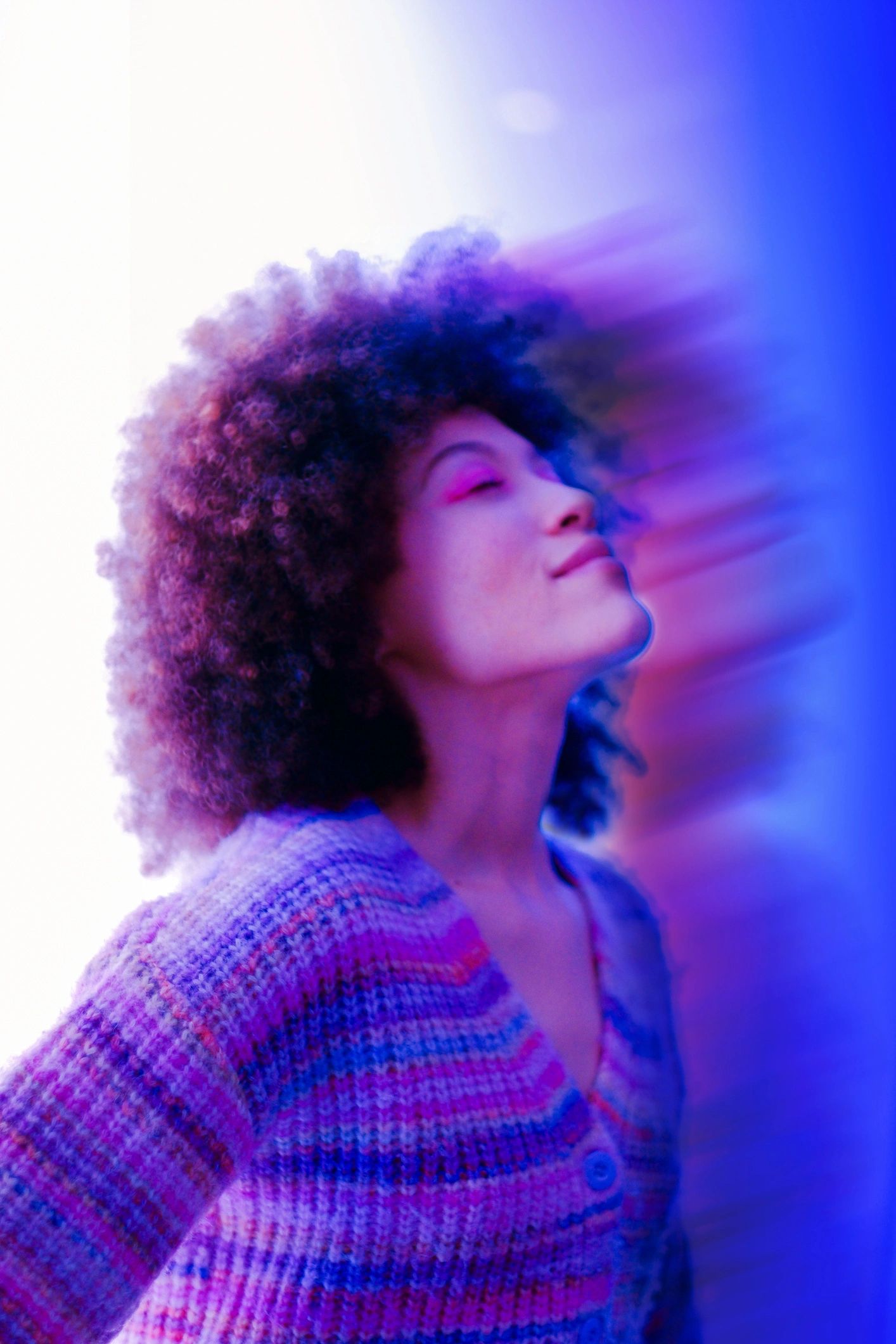 Back view portrait of a woman in a glowing purple and blue environment
